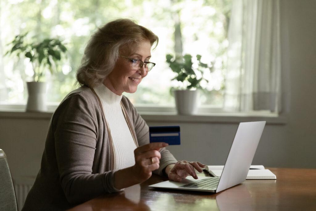 Woman at laptop holding credit card. Phishing attacks can lead to the theft of payment card information and even fraudulent payments or purchases. Phishing simulations can help prevent the theft of that information by training users for what to look for. 